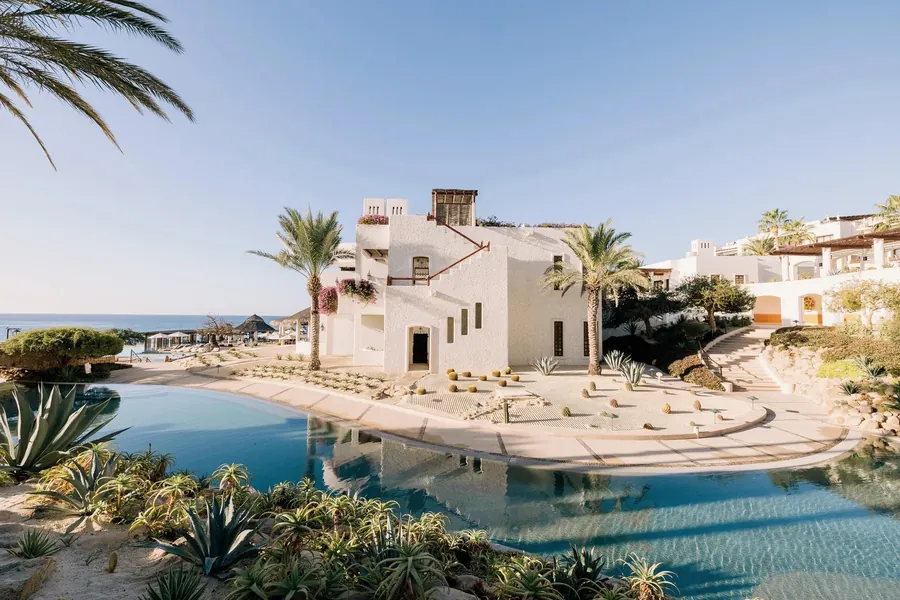 Rosewood Las Ventanas al Paraíso: pool, white buildings and desert plants above the sea in morning light